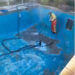 hitech worker removing coating in pool